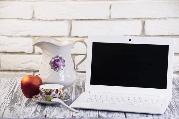 Beyaz dizüstü bilgisayar ve bir bardak süt 