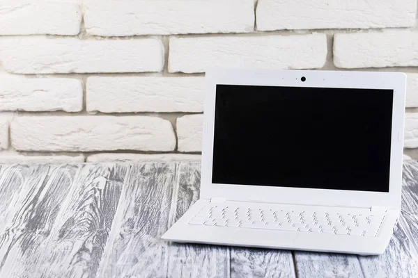 bir tuğla ve ahşap arka plan üstünde laptop