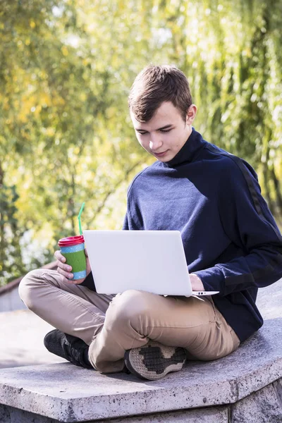 Adolescente trabalha atrás de um laptop — Fotografia de Stock