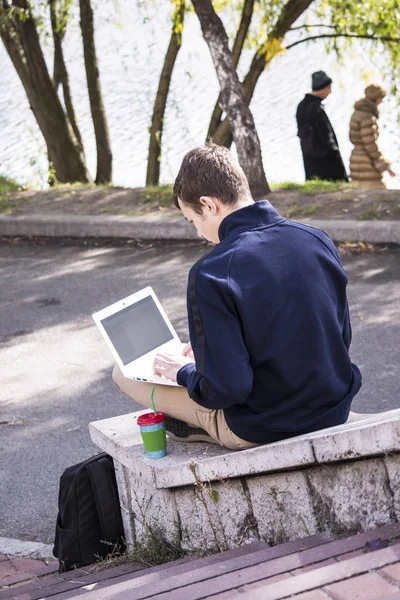 Adolescente trabalha atrás de um laptop — Fotografia de Stock