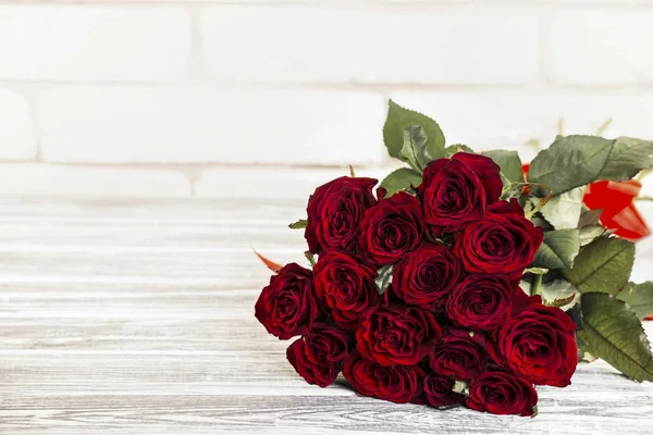 Bouquet de roses sur fond brique et bois — Photo