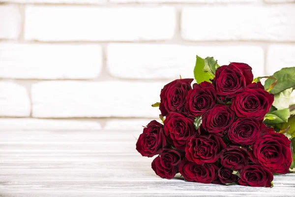 Bouquet de roses sur fond brique et bois — Photo