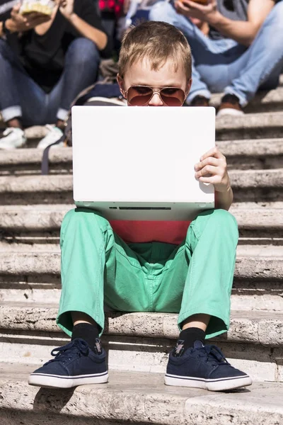 Забавный мальчик, играющий в ноутбук — стоковое фото