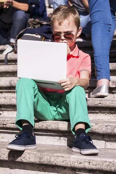 Забавный мальчик, играющий в ноутбук — стоковое фото