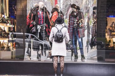 Sevimli kız moda mağaza pencere görünüyor