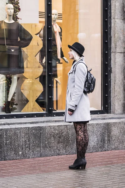 Sevimli kız moda mağaza pencere görünüyor