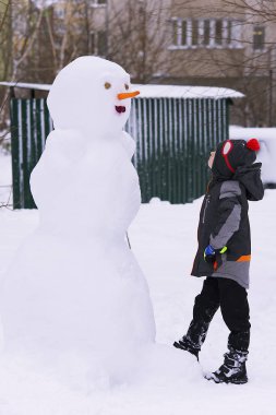 karda kışın kardan adam ve bir çocuk