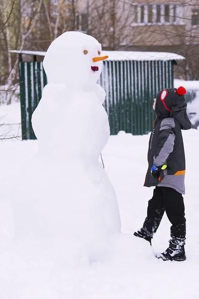 雪人在冬季的雪和一个男孩 — 图库照片