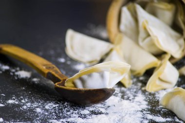 siyah bir tabloda bir kaşık et çiğ köfte dolması