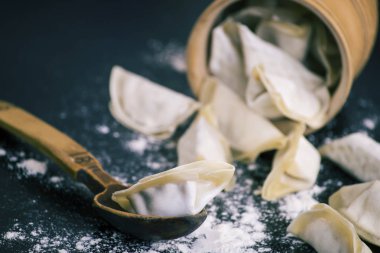 siyah bir tabloda bir kaşık et çiğ köfte dolması