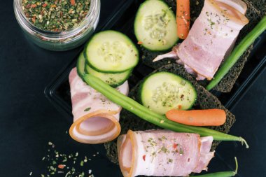jambon sebze ve baharat bir tablo ile bir siyah ekmek üzerinde