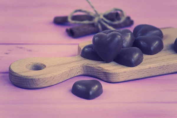 chocolate heart on a pink wooden board