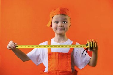 bir mezura turuncu bir arka plan üzerinde tutarak komik Oluşturucusu çocuk