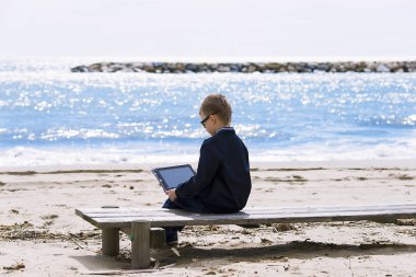 Baharda seashore tablete oynayan çocuk