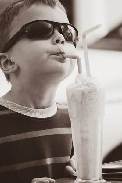 有趣的男孩吃草莓鸡尾酒冰淇淋在街道咖啡馆在春天 — 图库照片