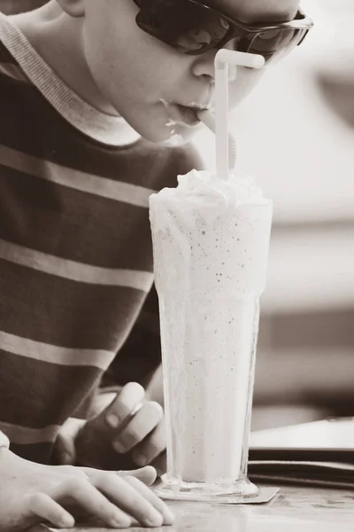 有趣的男孩吃草莓鸡尾酒冰淇淋在街道咖啡馆在春天 — 图库照片