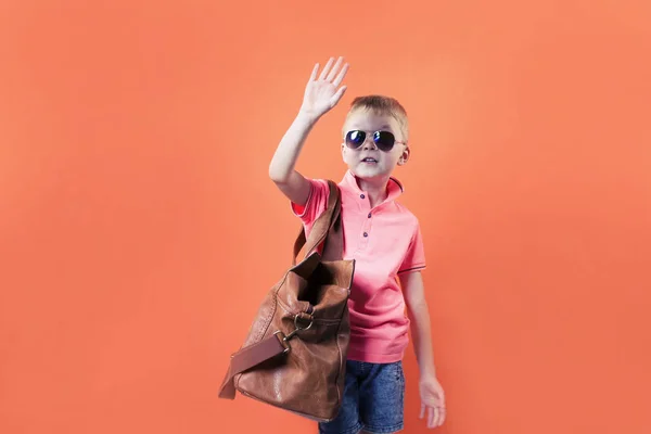 有趣的男孩与一个手提箱在明亮的橙色背景旅行 — 图库照片