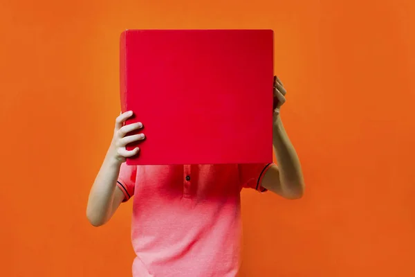 Grappige Jongen Houdt Een Vak Een Helder Oranje Achtergrond — Stockfoto