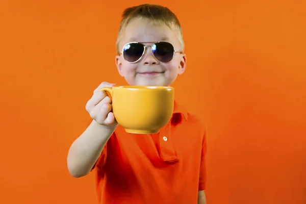 Divertente Ragazzo Tiene Grande Tazza Arancio Luminoso Sfondo — Foto Stock