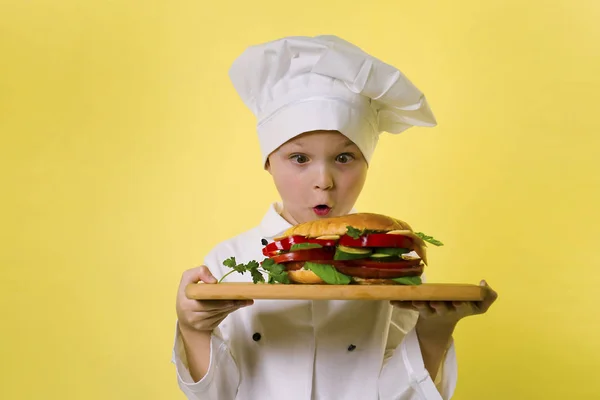 Lustige Junge Koch Kochte Ein Großes Sandwich Auf Einem Leuchtend — Stockfoto