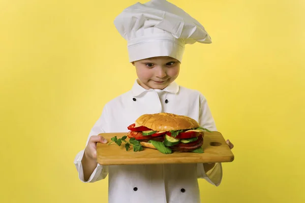 Αστείος Αγόρι Σεφ Μαγειρεμένα Ένα Μεγάλο Σάντουιτς Ένα Φωτεινό Κίτρινο — Φωτογραφία Αρχείου