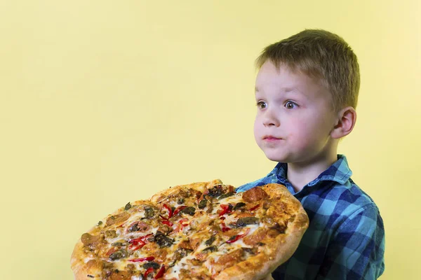 Zabawny Chłopak Jedzenie Big Pizza Jasnym Tle Żółty — Zdjęcie stockowe