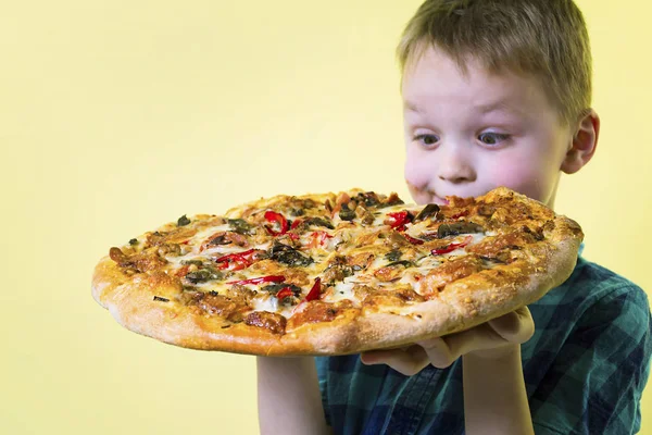 Lustiger Junge Isst Eine Große Pizza Auf Leuchtend Gelbem Hintergrund — Stockfoto