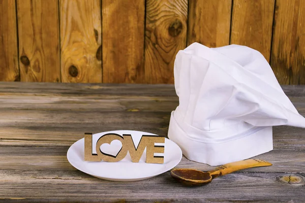 Chef's cap on an old wooden background, I love to cook