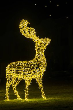 Yılbaşı geyiği gecenin karanlığında çimlerin üzerinde parıldıyor