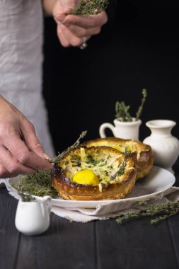 Ahşap bir arka planda jambonlu, yeşilli, peynirli ve yumurtalı ekmek.