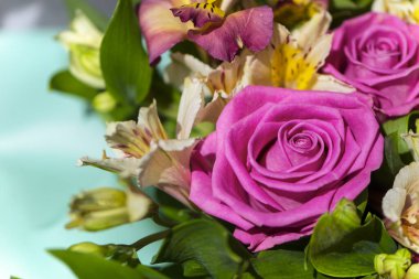 Güzel pembe güllerin arka planında bir buket çiçeğin içinde