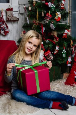 Çok güzel bir kız mutlu bir şekilde kendimi gülümseyen bir Noel ağacı yakınındaki