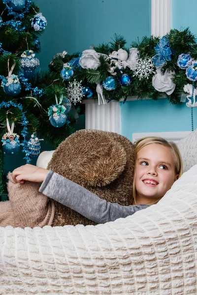 Sehr schönes Mädchen in der Nähe eines Weihnachtsbaums lächelnd und träumend ein — Stockfoto