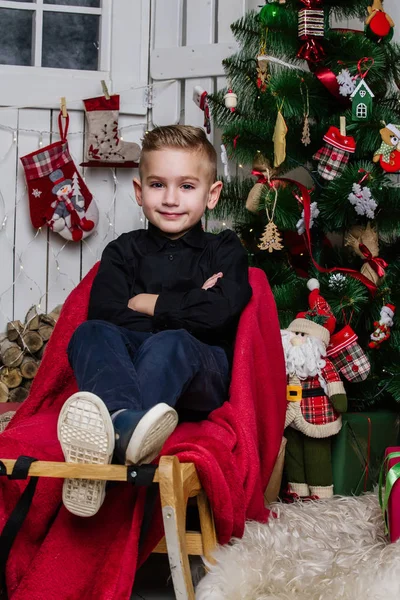 Chica muy hermosa cerca de un árbol de Navidad sonriendo y sosteniendo un regalo — Foto de Stock