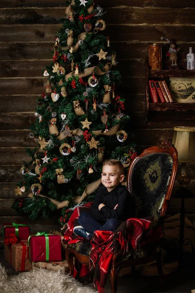 Πολύ όμορφο κορίτσι κοντά ένα χριστουγεννιάτικο δέντρο χαμογελώντας και κρατώντας ένα δώρο — Φωτογραφία Αρχείου