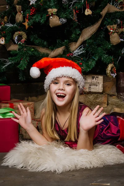 Heel mooi meisje in de buurt van een kerstboom glimlachend en houden een — Stockfoto