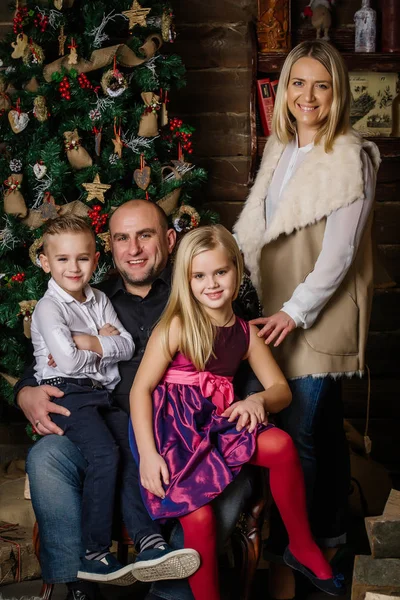 Família muito bonita sentada ao redor da árvore de Natal, e véspera — Fotografia de Stock