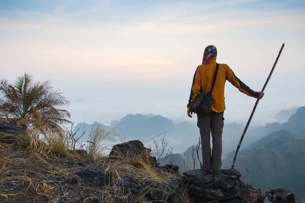 Людина сидить на кам'яній вершині високої гори — стокове фото