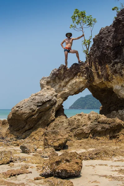 Сексуальный бродяга с пляжа, берущий камень — стоковое фото