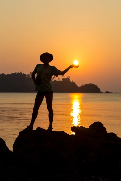 Young adult raising arms to the sea at sunset hands up