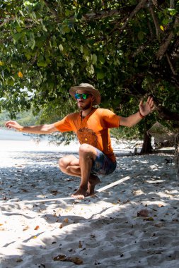 Genç kız halatla dengede duruyor ve gökyüzü kumsala bakıyor.