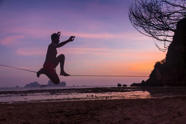 Teenage girl balancing on slackline with sky view on the beach — Stock Photo, Image