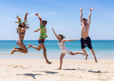 Arkadaşlar eğlence günbatımı güneş ışığı altında sahilde.