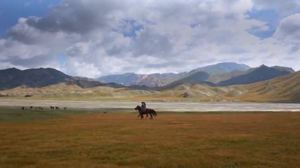 Atardecer tiro de cuatro vaqueros cabalgando hacia el atardecer hacia las montañas en el fondo . — Vídeo de stock