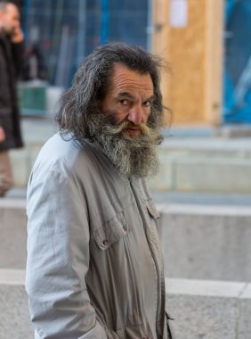 Almanya, Frankfurt: 12 Aralık 2016 - ciddi yakışıklı hipster adam beton duvar kutusu eğilerek kış giysileri içinde