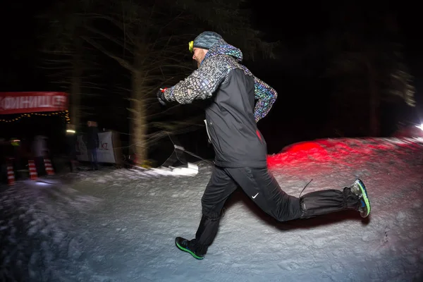 ALMATY, KAZAKHSTAN - 18 FEBRERO 2017: Concursos nocturnos en las estribaciones de la ciudad de Almaty, en la disciplina Trailrunning y Skyship, que se llama edición de invierno TunRun. Hombre corriendo en el — Foto de Stock