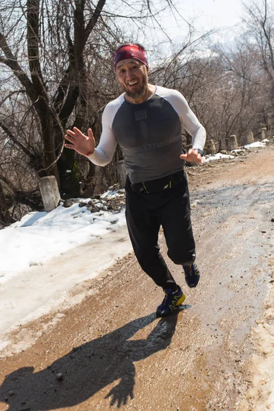 Alma-Ata, Kazachstan--09 April 2017: Amateur competities - berg halve marathon, in de uitlopers van Almaty, op de Yunat-meren. Sportieve jonge man loopt in de natuur. Gezonde levensstijl — Stockfoto