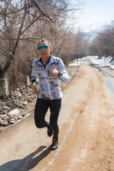 ALMATY, KAZAKHSTAN - 09 APRILE 2017: Concorsi amatoriali - Mezza maratona di montagna, ai piedi di Almaty, sui laghi di Yunat. corridore - donna che corre all'aperto ad allenarsi per la corsa di maratona. Bello. — Foto Stock