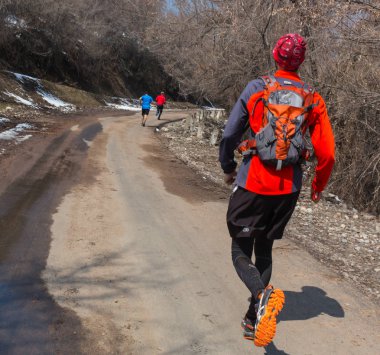 Almatı, Kazakistan - 09 Nisan 2017: Amatör yarışmalar - dağ yarı maraton, Almatı, Yunat göller üzerinde eteklerinde. Doğada koşan atletik genç adam. Sağlıklı yaşam tarzı