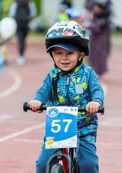 KAZAKHSTAN, ALMATY - JUNE 11, 2017: Childrens cycling competitions Tour de kids. Children aged 2 to 7 years compete in the stadium and receive prizes. A little boy rides a bike and competes to become — Stock Photo, Image